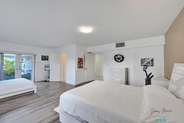 bedroom with access to exterior, french doors, and hardwood / wood-style flooring