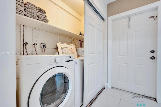 laundry area with light tile patterned floors and washing machine and dryer