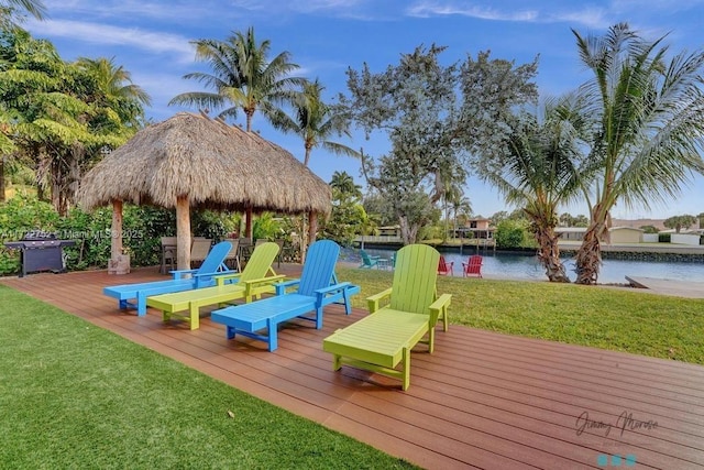 deck featuring a gazebo, a yard, a water view, and grilling area