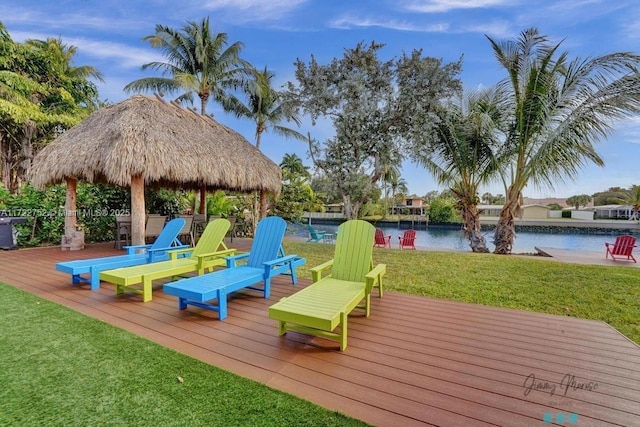 wooden terrace with a gazebo, a water view, and a yard