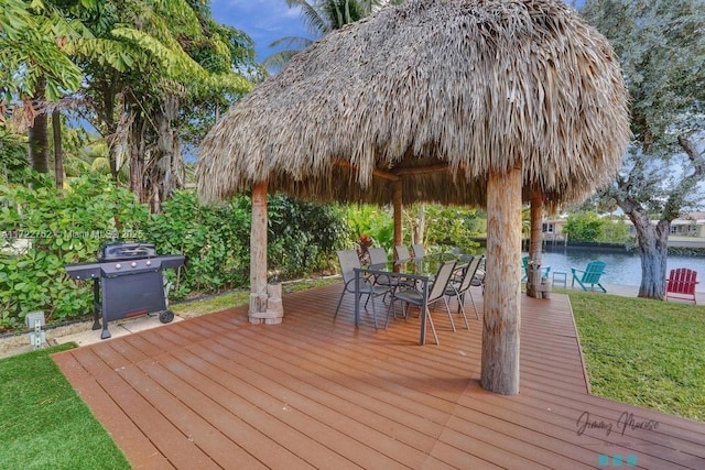 wooden deck with a gazebo, a water view, and a grill