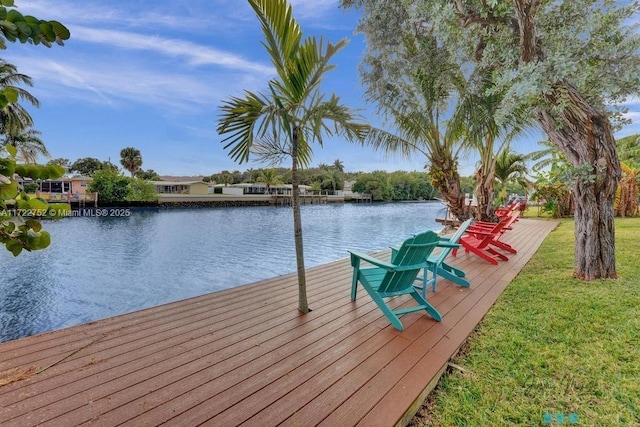 dock area with a lawn and a water view