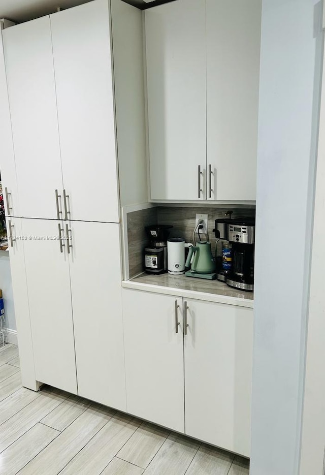 bar with white cabinetry and decorative backsplash