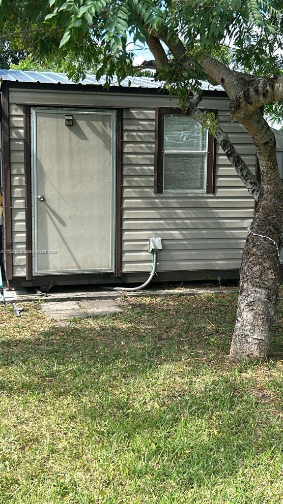 view of property exterior with an outdoor structure and a yard