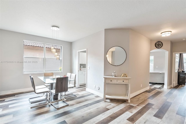 dining area featuring a textured ceiling and light hardwood / wood-style floors