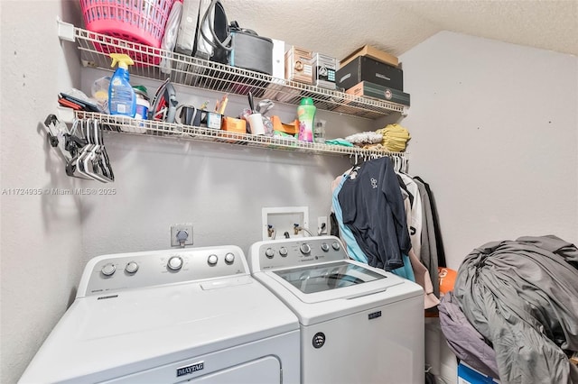 laundry area with washing machine and dryer and a textured ceiling