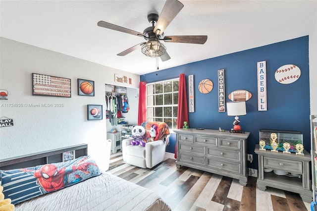 bedroom with wood-type flooring, ceiling fan, and a closet