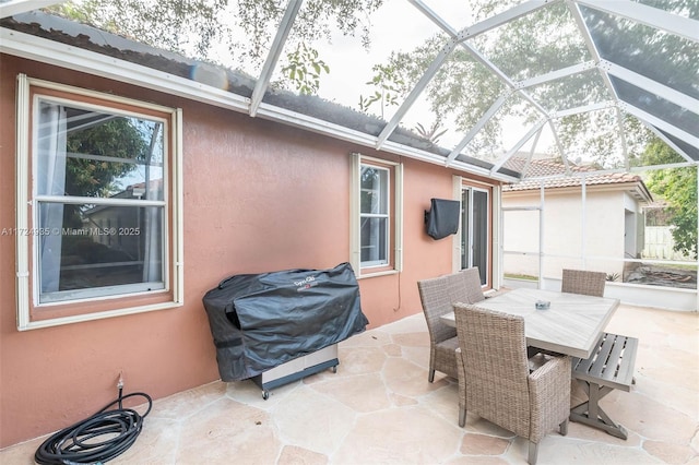 view of patio with a grill and glass enclosure