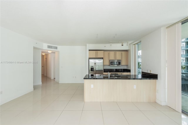 kitchen featuring sink, light brown cabinets, kitchen peninsula, light tile patterned floors, and appliances with stainless steel finishes