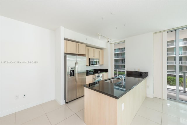 kitchen with sink, stainless steel appliances, kitchen peninsula, light brown cabinetry, and light tile patterned floors