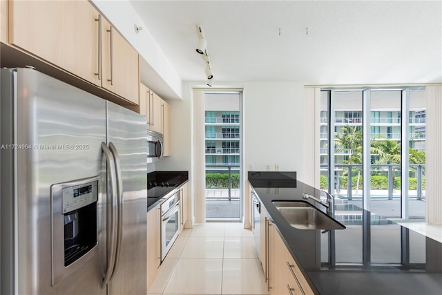 kitchen with light brown cabinets, light tile patterned floors, sink, and appliances with stainless steel finishes