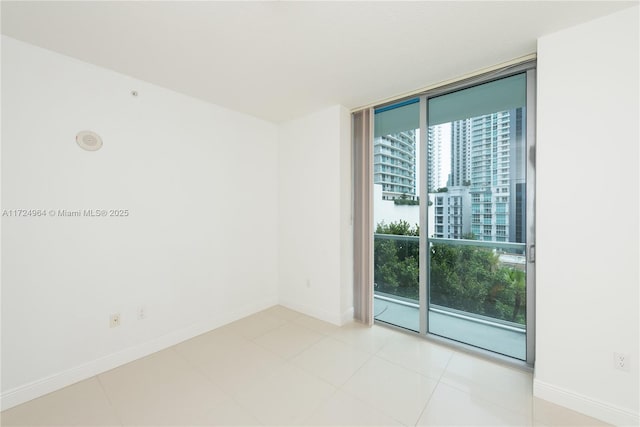 tiled spare room featuring expansive windows