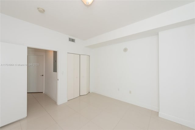 unfurnished bedroom with light tile patterned floors and a closet