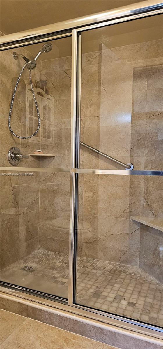 bathroom with a shower with door