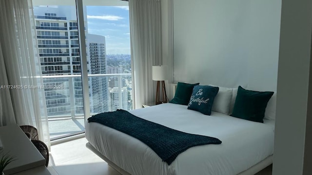 bedroom with multiple windows, access to exterior, and a wall of windows