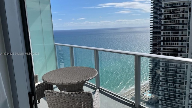 balcony with a water view and a beach view