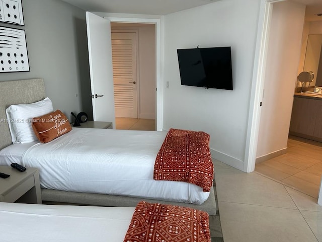 tiled bedroom featuring ensuite bath