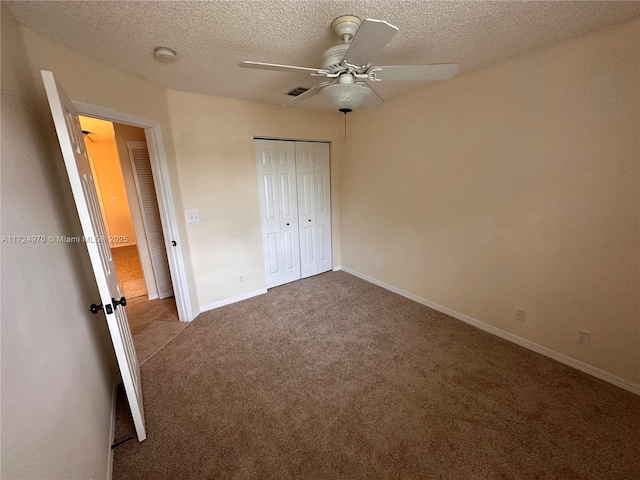 unfurnished bedroom with ceiling fan, carpet floors, a closet, and a textured ceiling