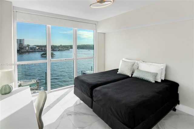 bedroom with a water view and expansive windows