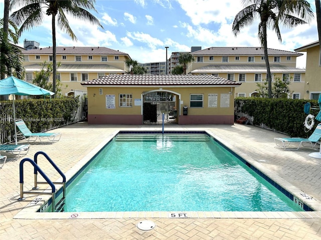 pool featuring an outbuilding, a patio area, fence, and a storage structure