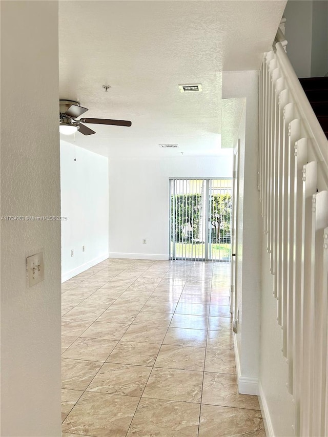 spare room featuring visible vents, a textured ceiling, and baseboards