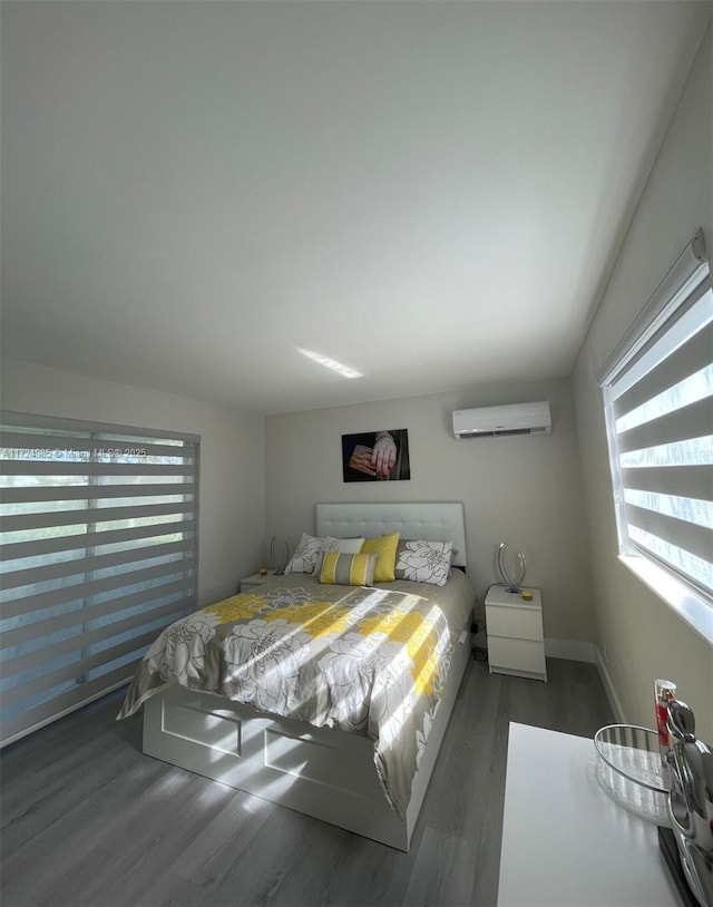 bedroom featuring dark hardwood / wood-style flooring and an AC wall unit