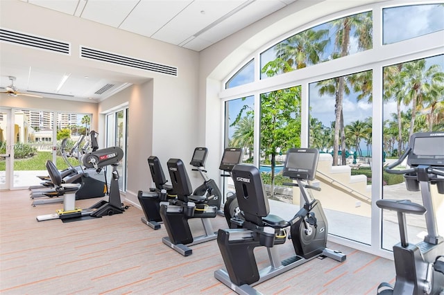 workout area with ceiling fan and light colored carpet