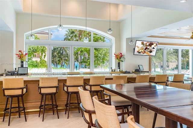 bar with ceiling fan and a towering ceiling