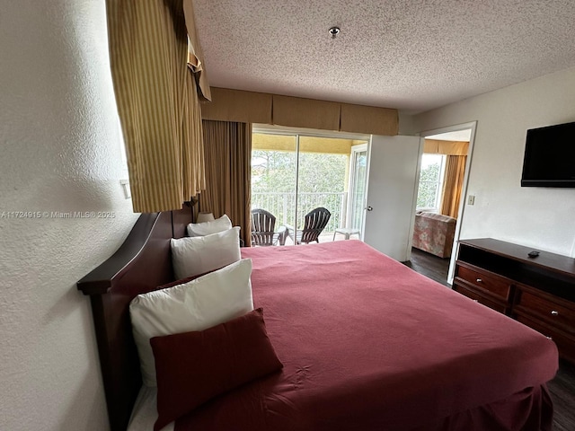 bedroom with a textured ceiling and access to outside