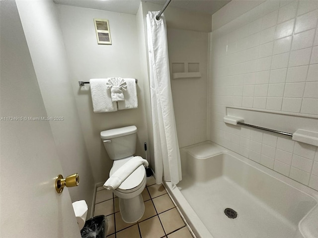 bathroom featuring tile patterned flooring, a shower with shower curtain, and toilet