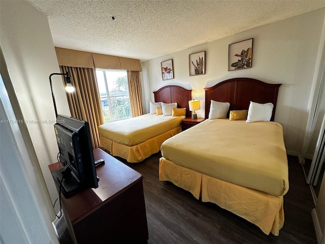 bedroom with a textured ceiling and dark wood-type flooring