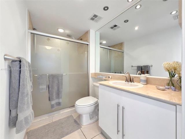 bathroom featuring toilet, vanity, a shower with door, and tile patterned floors