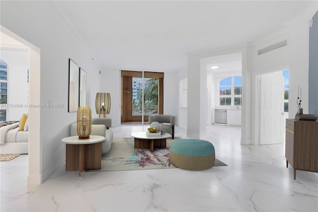 living area featuring marble finish floor, a wealth of natural light, visible vents, and baseboards