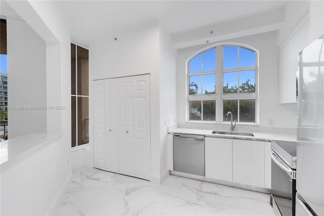 kitchen featuring appliances with stainless steel finishes, white cabinets, a sink, and modern cabinets