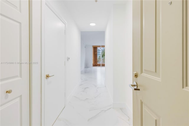 hall featuring marble finish floor and baseboards