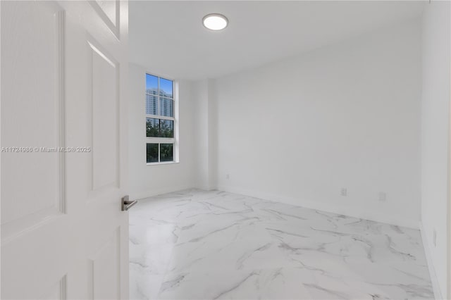 spare room featuring marble finish floor