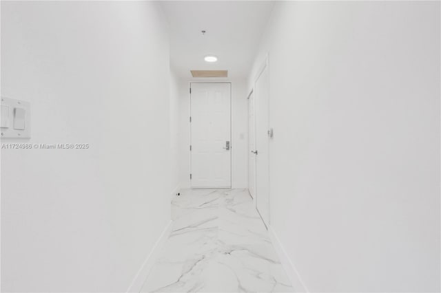 hall featuring marble finish floor and baseboards