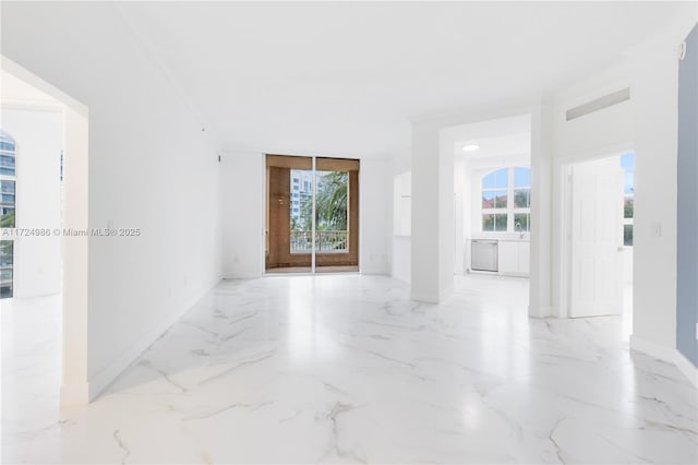 spare room with marble finish floor, visible vents, and a wealth of natural light