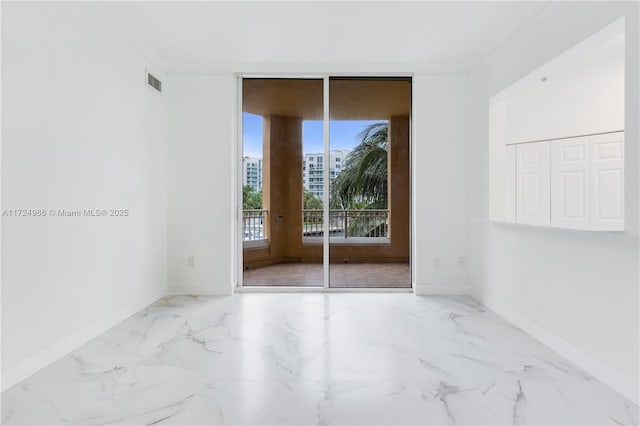 spare room featuring expansive windows, marble finish floor, and baseboards