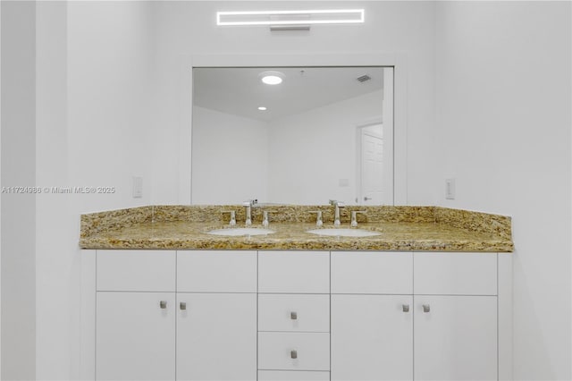 bathroom featuring recessed lighting, visible vents, a sink, and double vanity