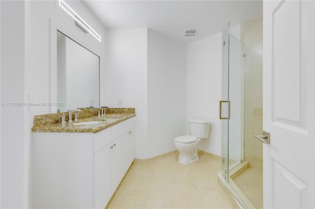 bathroom featuring toilet, a stall shower, tile patterned flooring, and a sink