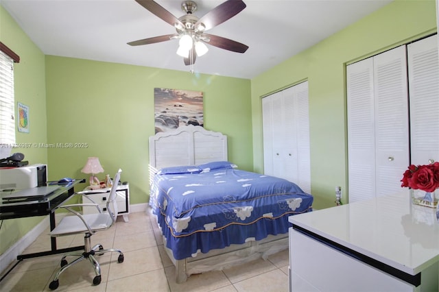 tiled bedroom with multiple closets and ceiling fan