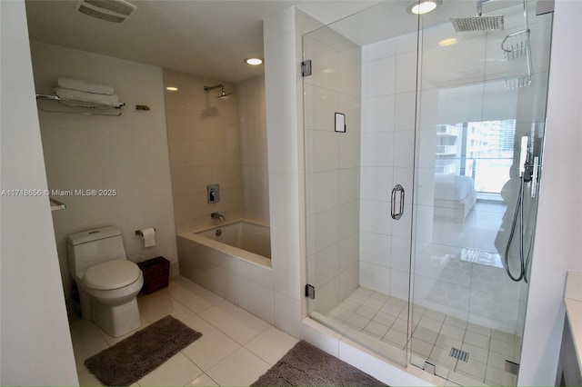 bathroom featuring tile patterned flooring, toilet, and independent shower and bath