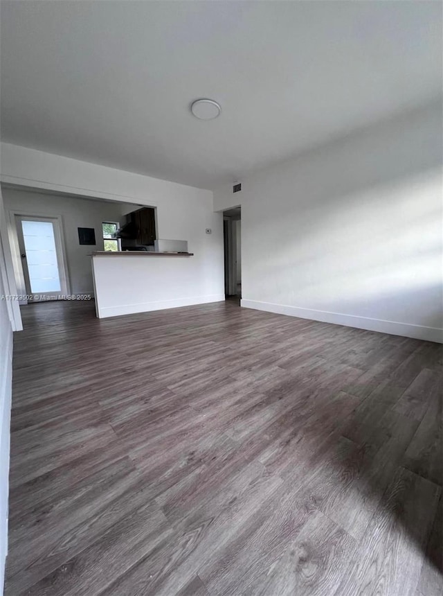 unfurnished living room featuring dark wood-type flooring