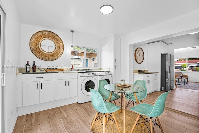 dining room featuring washing machine and clothes dryer and light wood-type flooring