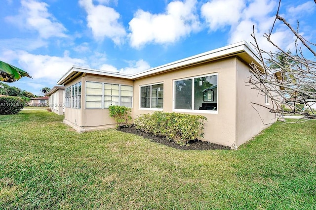 view of side of home with a yard