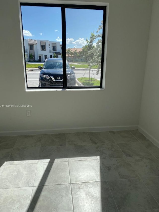 tiled empty room with a wealth of natural light