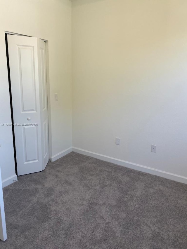 spare room with dark carpet