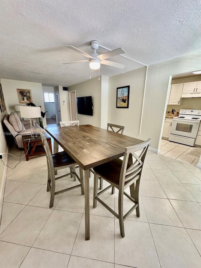 dining area featuring light tile patterned floors, a textured ceiling, and ceiling fan