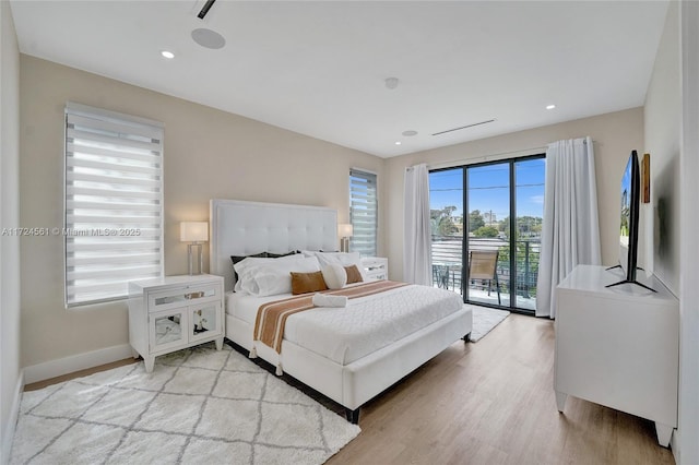 bedroom featuring light hardwood / wood-style floors, access to outside, and multiple windows